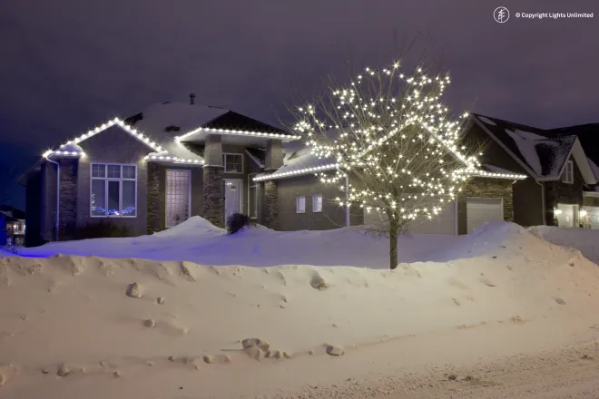 Warm white Christmas lights on a house and tree in East St. Paul, MB