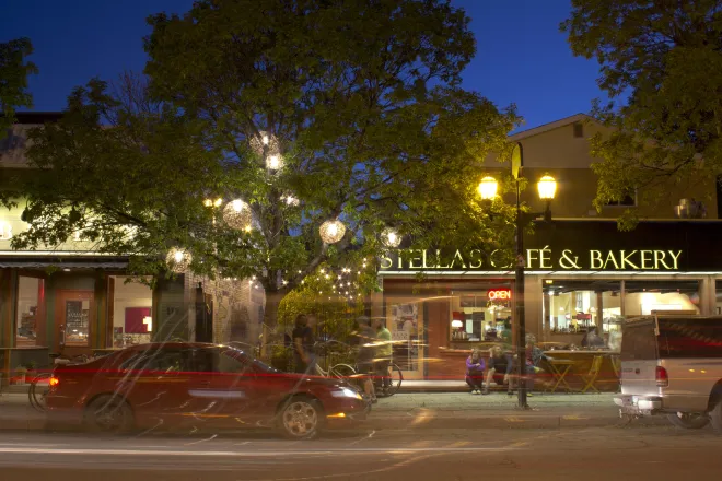 Warm white light spheres installed in trees above a busy commercial street in Winnipeg, MB