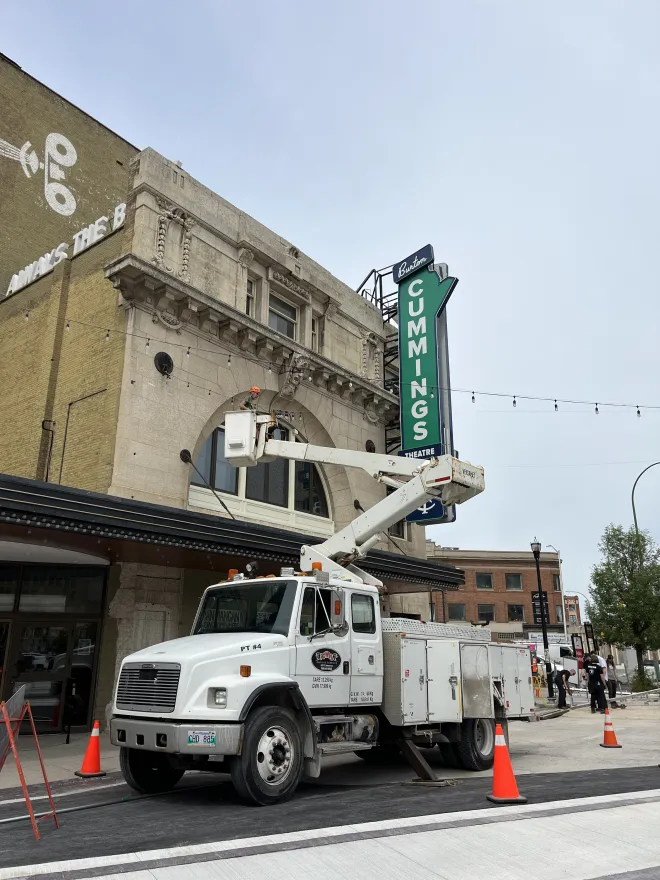 Some of our professional light installers work to set up overhead festoons outside the Burton Cummings Theatre, Winnipeg, MB
